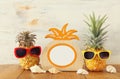 Empty photo frame and couple of funny pineapple with sunglasses. For photography and scrapbook montage Royalty Free Stock Photo