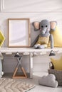 Empty photo frame and cute toy elephant near wall in baby room. Interior design Royalty Free Stock Photo