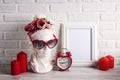 Empty photo frame with female plaster head with heart shaped glasses, flowers, alarm clock and candles against the white brick Royalty Free Stock Photo