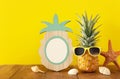 Empty photo frame and funny pineapple with sunglasses. For photography and scrapbook montage
