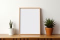 Empty Photo Frame on Wooden Table with Houseplants as Room Decoration on White Wall Background