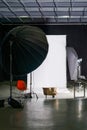 Empty photo studio with modern interior and lighting equipment. Preparation for studio shooting: empty chair and studio lighting.