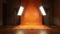 Empty photo studio setup with professional lighting softboxes aimed at an orange textured backdrop. Interior space prepared for a Royalty Free Stock Photo