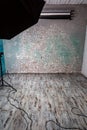 Empty photo studio with shabby wooden floor, brick wall, backdrops, light. Brown gray tones. Vertical orientation. Royalty Free Stock Photo