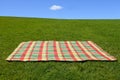 An empty picnic blanket on green grass Royalty Free Stock Photo