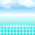 Empty picnic table, covered checkered tablecloth.