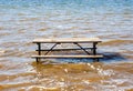 Empty picnic table in muddy brown water Royalty Free Stock Photo