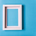 Empty picture frame against blue paper background. Royalty Free Stock Photo