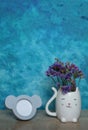 an empty picture frame and a cat Vase with statice flowers on wooden table against blue wall background, mock up Royalty Free Stock Photo