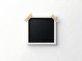 Empty picture frame with tape attached on light grey wall surface Royalty Free Stock Photo