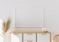 Empty picture frame on white wall in modern living room. Mock up interior in scandinavian, boho style. Close up view Royalty Free Stock Photo