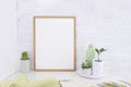 Empty picture mockup with wooden frame on white brick wall background with succulents plants and green vase. Royalty Free Stock Photo