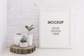 Empty picture mockup with wooden frame on white brick wall background with succulents plants on a wooden cut. Royalty Free Stock Photo