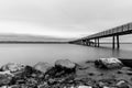 an empty pier surrounded by rocks and water on a cloudy day Royalty Free Stock Photo