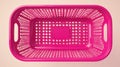 Empty pink plastic basket with perforated design, top-down view on pastel background, emphasizing shape Royalty Free Stock Photo