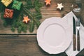 Empty pink plate, glass, cutlery, decorations on wooden background. Christmas table setting captured from above. Top view, flat Royalty Free Stock Photo