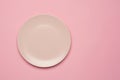 Empty pink plate on the pastel pink background. Flat lay, top view.