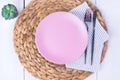Empty pink plates, a knife and a fork on a straw eco-friendly napkin Royalty Free Stock Photo