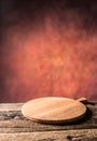 Empty pizza round board old wooden table and colour blurred bac