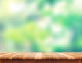 Empty plank brown wood table top with blur green tree background Royalty Free Stock Photo