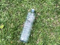 Empty plastic bottle close-up on green grass top view. Plastic garbage. Recycling. Ecological situation. Separation trash