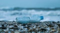 An empty plastic bottle lies discarded on a beach but upon closer inspection one can see tiny organisms growing on the Royalty Free Stock Photo