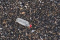Empty plastic bottle on a pebble beach, the concept of plastic pollution. Royalty Free Stock Photo