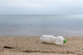 Empty plastic bottle on the sand. Garbage on the beach. Sea shore. Environmental pollution