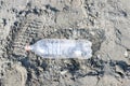 Empty plastic bottle trash laying on a sandy beach. Plastic pollution concept Royalty Free Stock Photo