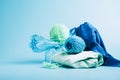 Empty plastic bottle and various fabrics made of recycled polyester fiber synthetic fabric on a blue background