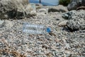 Empty plastic garbage dumped on pebble stones Royalty Free Stock Photo