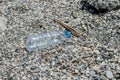 Empty plastic garbage dumped on pebble stones Royalty Free Stock Photo