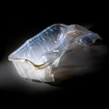 Empty plastic packaging for food shown like an art sculpture against a black background, waste of the abundance and throwaway Royalty Free Stock Photo