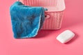 Empty plastic square basket for washing with blue soft towel near antibacterial soap lies on pink countertop in laundry Royalty Free Stock Photo