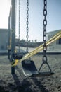 Empty plastic swings on playground with caution tape, selective focus Royalty Free Stock Photo