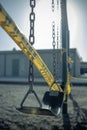 Empty plastic swings on playground with caution tape, selective focus Royalty Free Stock Photo