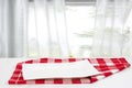 Empty plate background. Empty white plate on table with red napkin or tablecloth over blurred curtain window natural light green Royalty Free Stock Photo