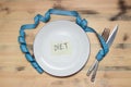 Empty plate with blue measure tape, knife and fork Royalty Free Stock Photo