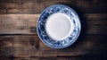 Empty Plate with a blue napkin on a wooden table shot from above. AI Generated