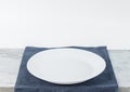Empty plate on tablecloth on wooden table over grunge background Royalty Free Stock Photo