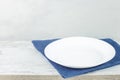 Empty plate on tablecloth on wooden table over grunge background Royalty Free Stock Photo