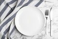 Empty plate with cutlery and fabric on marble table, flat lay Royalty Free Stock Photo