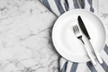 Empty plate with cutlery and fabric on marble table, flat lay. Space for text Royalty Free Stock Photo