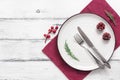 Empty plate with cutlery and napkin on a wooden white background. Christmas table setting. Top view, flat lay Royalty Free Stock Photo