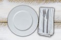 Empty plate and cutlery on olive-white wood