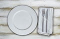 Empty plate and cutlery on olive-white wooden background