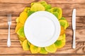 Empty plate with fork, knife and autumn leaves on wooden table. Top view Royalty Free Stock Photo