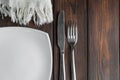Empty plate, fork and knife on dark wood background Royalty Free Stock Photo