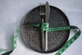 Empty plate, fork and knife, measuring tape nutrition Royalty Free Stock Photo