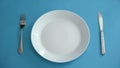 Empty plate and fork with knife set on table, dishwashing detergent, background Royalty Free Stock Photo
